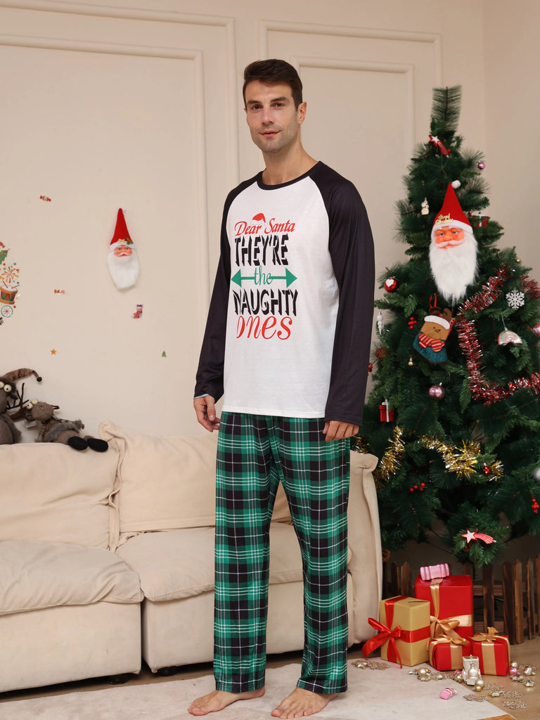 A child wearing Naughty or Nice pyjamas while unwrapping Christmas presents.